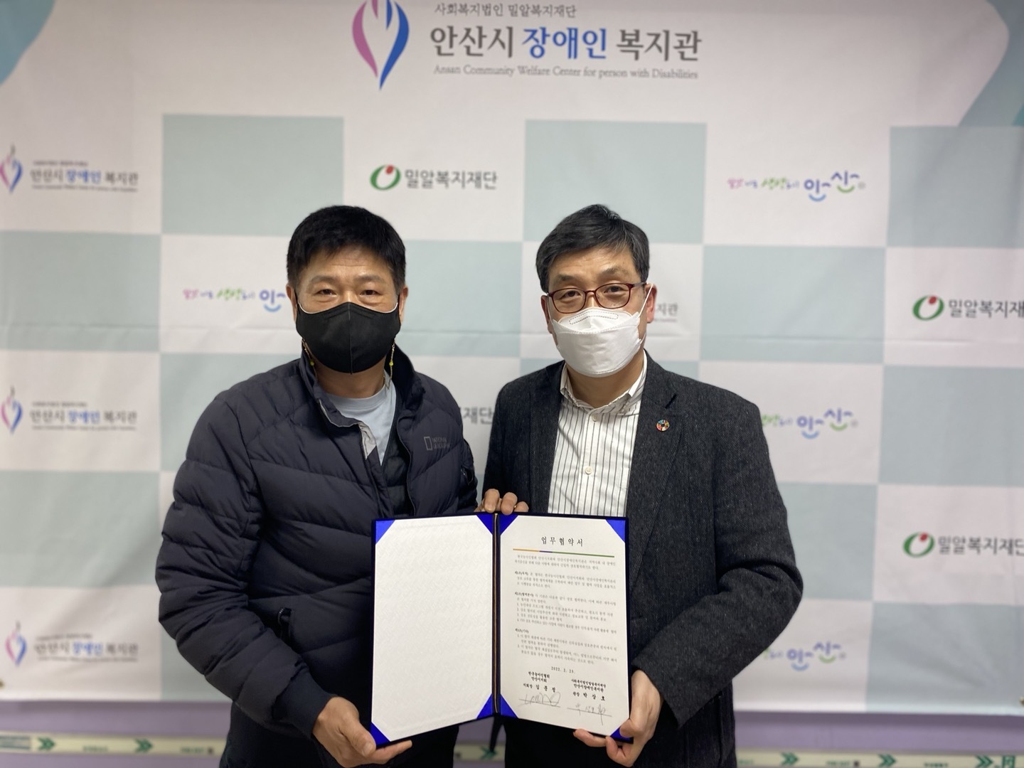 한국농아인협회 안산시지회 관계자와 안산시장애인복지관장님이 나란히 업무협약서를 들고 있는 모습